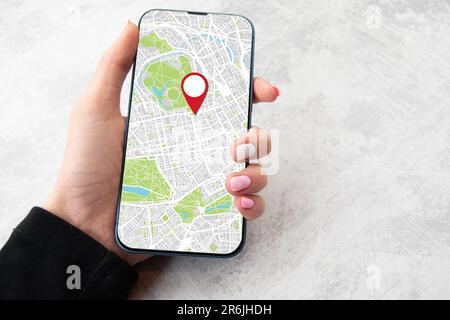 Girls hand holding smart phone with picture of on line maps. Marble back ground copy space Stock Photo