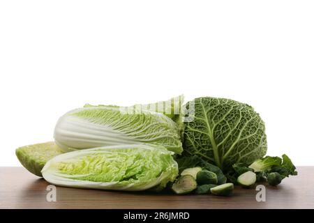Different types of cut cabbage on wooden table against white background Stock Photo