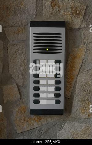 Modern intercom on concrete wall with stone fragments. Security system Stock Photo