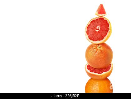 Stacked cut and whole grapefruits on white background Stock Photo