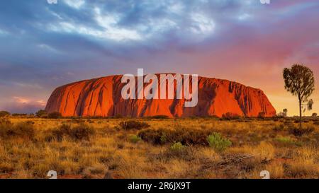 Uluru, Northern Territory, Australia; June 10, 2023 -  Sunset at Uluru, the famous gigantic monolith rock in the Australian desert. Stock Photo