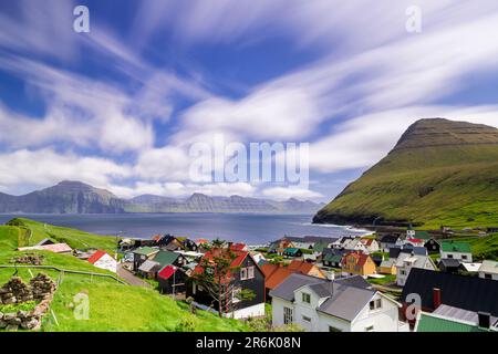 Fluffy clouds in the summer sky over the traditional houses of Gjogv, Eysturoy Island, Faroe Islands, Denmark, Europe Stock Photo