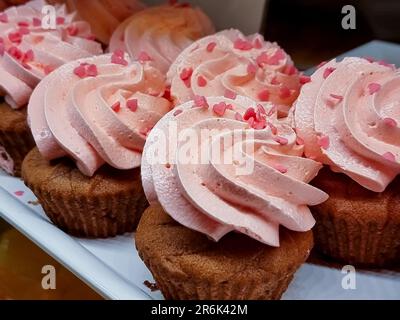 cupcakes with summer berries on blue wooden table Stock Photo