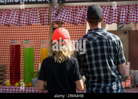 Couple in front of fair stall. Checkered pattern Stock Photo