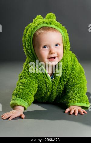 A cute cute baby in a furry frog costume Stock Photo