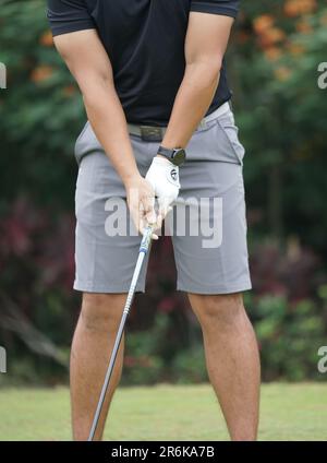 Jakarta, Indonesia - June 5, 2023: Close up of male hand holding golf club to make a shot Stock Photo