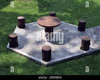 Oval seating with a round table in the middle made of cement in a garden Stock Photo