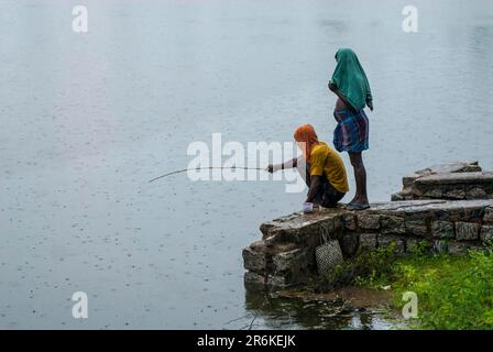 Village people angling during a rainy day, Tamil Nadu, South India, India, Asia Stock Photo