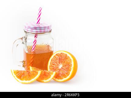 Jug of iced tea with orange slices isolated on white background. Copy space. Stock Photo