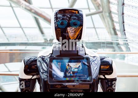 robot portrait close-up. smiling face of robot, photographer's reflection. Autonomous personal assistant robot for navigation direction in Museum Ener Stock Photo