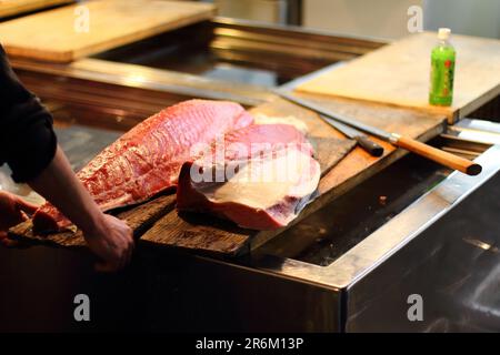A chef in a professional kitchen is preparing a selection of steaks, ready to be served Stock Photo
