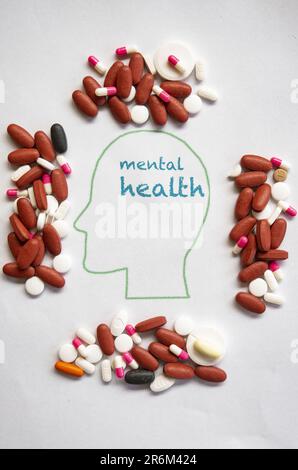 mental health concept with medicines surrounding drawing of a human brain Stock Photo