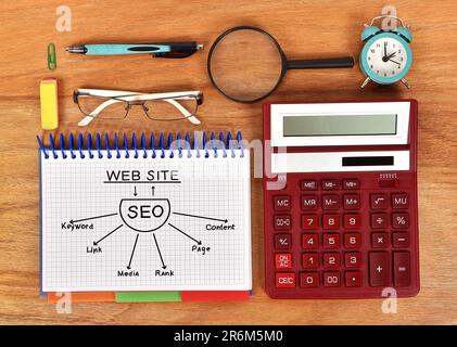 drawing seo scheme in notebook and red calculator Stock Photo