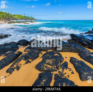 Waves Crash Over Exposed Lava Reef, Kauapea Beach, Kauai, Hawaii, USA Stock Photo