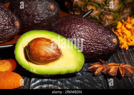 sliced hass avocado on wood background Stock Photo