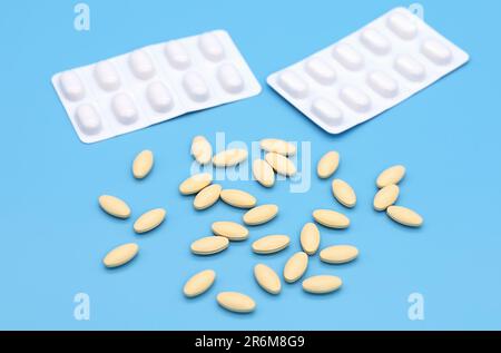 blisters and oval-shaped tablets lie on a contrasting background Stock Photo