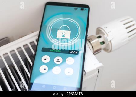 Smart Home: Man Controlling Heating Using App Stock Photo