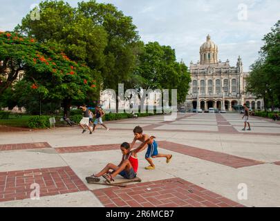 Havana, Cuba. Boys play with a cart in front of El Capitolio, Cuba’s capital building. Editorial use only. Stock Photo