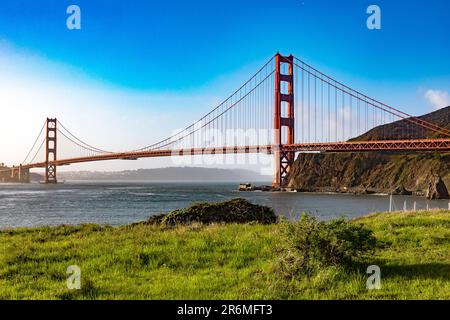 The Golden Gate Bridge over San Francisco Bay as seen from a green meadow overlook. The most famous bridge in the state of California in the USA. Brid Stock Photo
