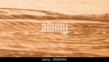 Natural wood background. Light olive wood veneer with contrasting brown stripes. Stock Photo