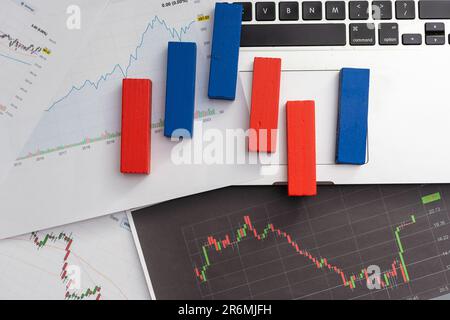 Stock market Charts . Two Hundred rolled us dollar bills staying on the graph. Two more hundred us dollar bills on the foreground. Macro image. Red Stock Photo