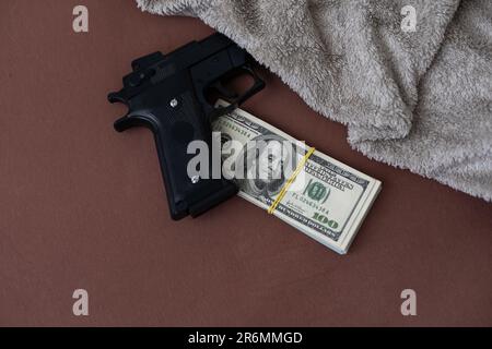 Handgun on the US dollars stack - - criminal money concept Stock Photo