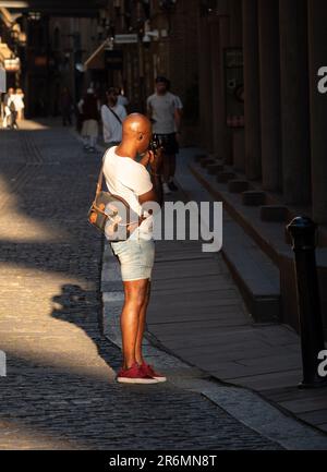 London, England, UK - July 10, 2022: An artist photographer in London who takes pictures of architecture and is lit by a ray of sunlight at golden hou Stock Photo