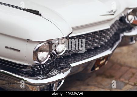 Izmir, Turkey - June 3, 2023: Close-up of the headlight of a white 1960 Cadillac at the IZKOD Classic Car Meet at Buca Pond in Izmir. Stock Photo