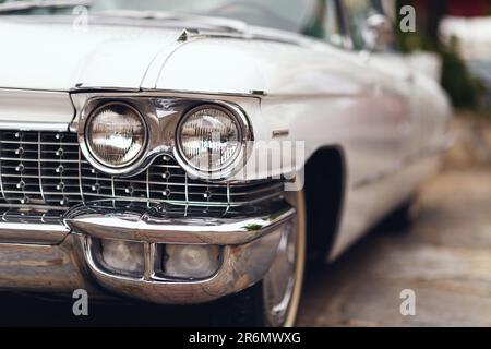 Izmir, Turkey - June 3, 2023: Close-up of the headlight of a white 1960 Cadillac at the IZKOD Classic Car Meet at Buca Pond in Izmir. Stock Photo