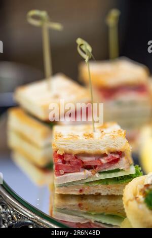 mini canape sandwiches with sausage and white bread close-up. Stock Photo