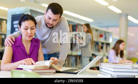 Man and woman working on joint research in library Stock Photo