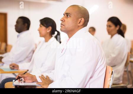 Hispanic man listening to lecture at medical congress Stock Photo
