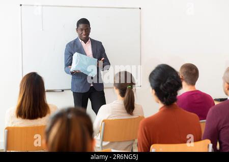 African american coach businessman giving talk at modern office conference to multiethnic team Stock Photo