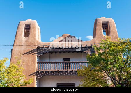 Horizontal image of the exterior front facade with bell towers of the Pueblo-Revival style building that houses the New Mexico Museum of Art in Santa Stock Photo
