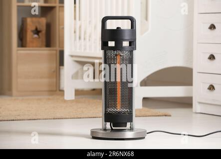 Modern infrared heater on floor in cozy room Stock Photo