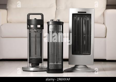Different modern infrared heater on floor in cozy room Stock Photo