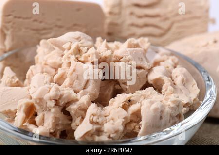Pieces of compressed yeast in glass bowl, closeup Stock Photo