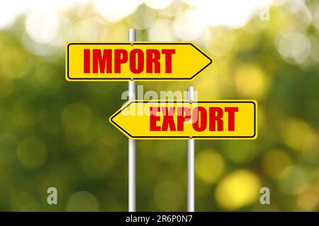 Road sign with Import and Export words on arrows pointing in opposite directions outdoors Stock Photo