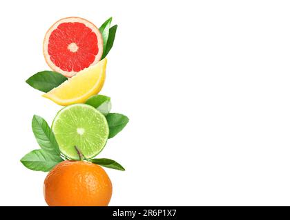 Stack of different fresh citrus fruits with green leaves on white background Stock Photo