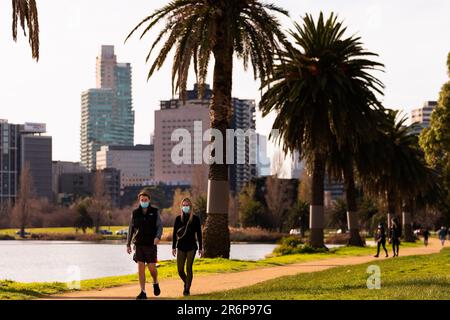 MELBOURNE, AUSTRALIA - JULY 24: People seen wearing masks in Albert Park Lake during COVID 19 on 24 July, 2020 in Melbourne, Australia. the Victorian Premier confirmed 300 new coronavirus cases overnight. As of 11.59pm on Wednesday 22 July, people living in metropolitan Melbourne and Mitchell Shire and will now be required to wear a face covering when leaving home, following a concerning increase in coronavirus cases in recent days. The fine for not wearing a face covering will be $200. Stock Photo