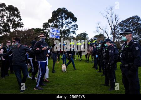 MELBOURNE, VIC - SEPTEMBER 05: Police and protesters stand off during the Anti-Lockdown Protest on September 05, 2020 in Sydney, Australia. Stage 4 restrictions are in place from 6pm on Sunday 2 August for metropolitan Melbourne. This includes a curfew from 8pm to 5am every evening. During this time people are only allowed to leave their house for work, and essential health, care or safety reasons. Stock Photo