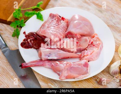 Chopped rabbit with garlic and spices on white plate with knife Stock Photo