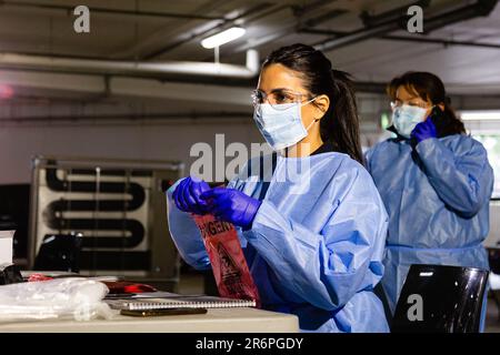 MELBOURNE, AUSTRALIA - APRIL 30: A nurse wearing full PPE processes tests at the Pacific Epping Shopping Centre as mobile testing sites pop up all over Melbourne during COVID 19 on 30 April, 2020 in Melbourne, Australia. Stock Photo