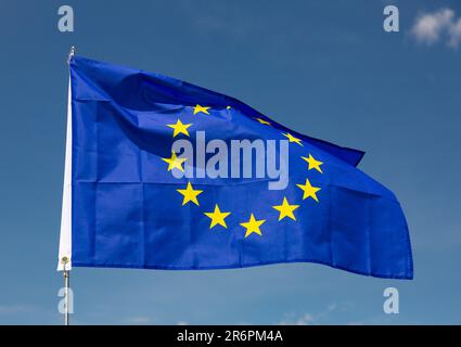 Flag of European Union waving on cloudy sky during daytime Stock Photo