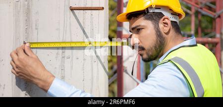 Engineer young man using tape measure for check and examining length of structure with professional at construction site, architect inspection and imp Stock Photo