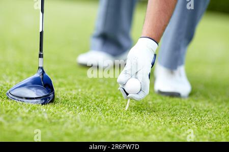 Golf, closeup of man with sports club and ball on the grass course outside. Training or practice, sports with equipment and hand of a male athlete Stock Photo