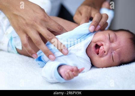 Newborn, cleft palate and mother care for a baby crying in a home bed feeling tired in a bedroom or medical centre. Health, healthcare and young child Stock Photo