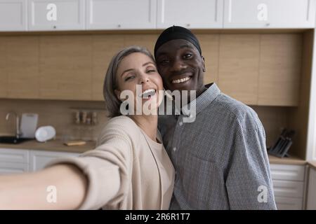 Happy multiethnic African and Caucasian couple taking selfies at home Stock Photo