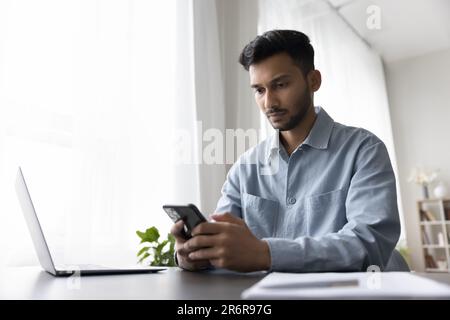 Focused serious young Indian business man using Internet technology Stock Photo