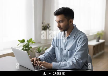 Focused young Indian professional man working on business project Stock Photo